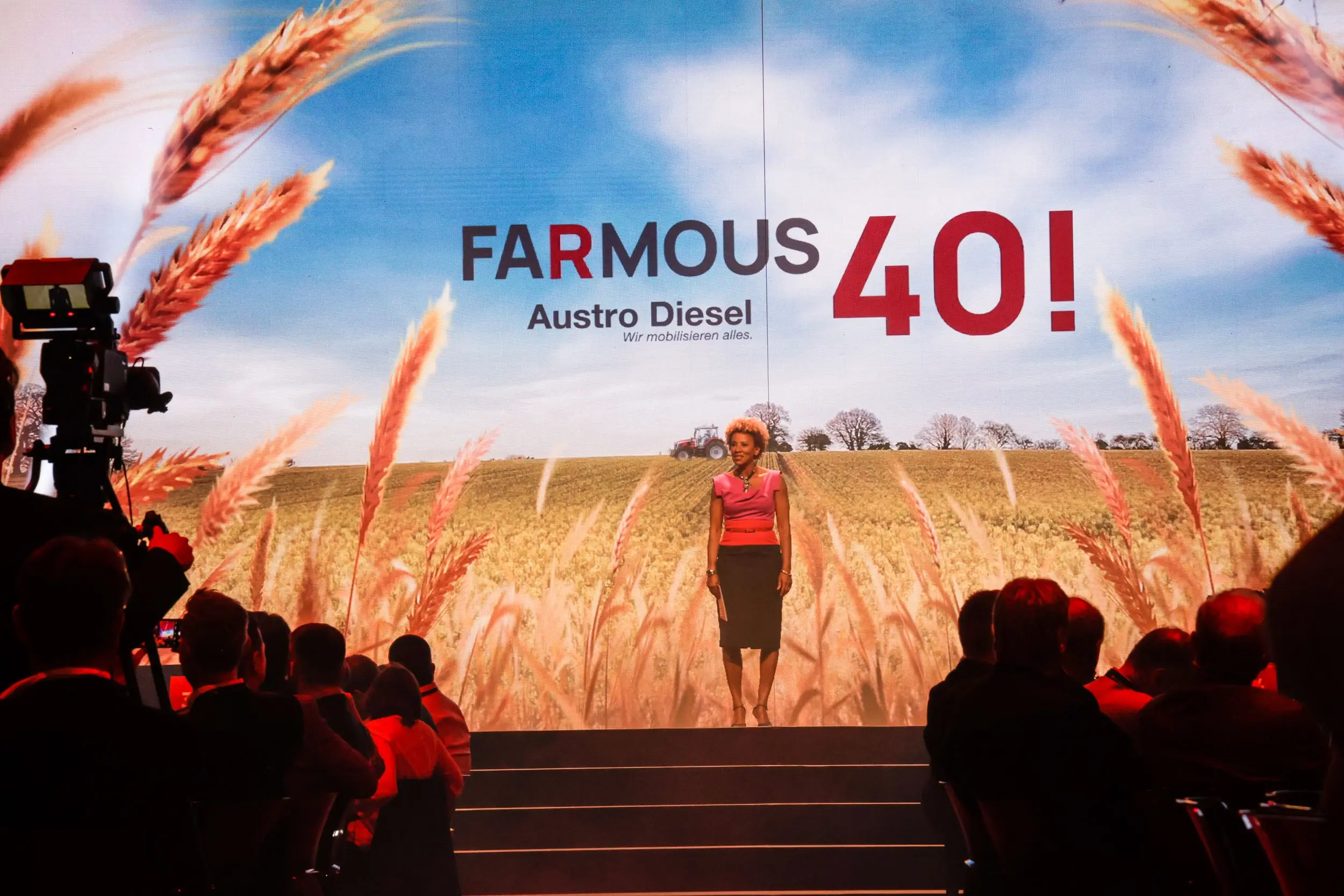 Bühne beim Austro Diesel Event „Farmous 40“ mit Moderatorin vor einer Getreidefeld-Projektion