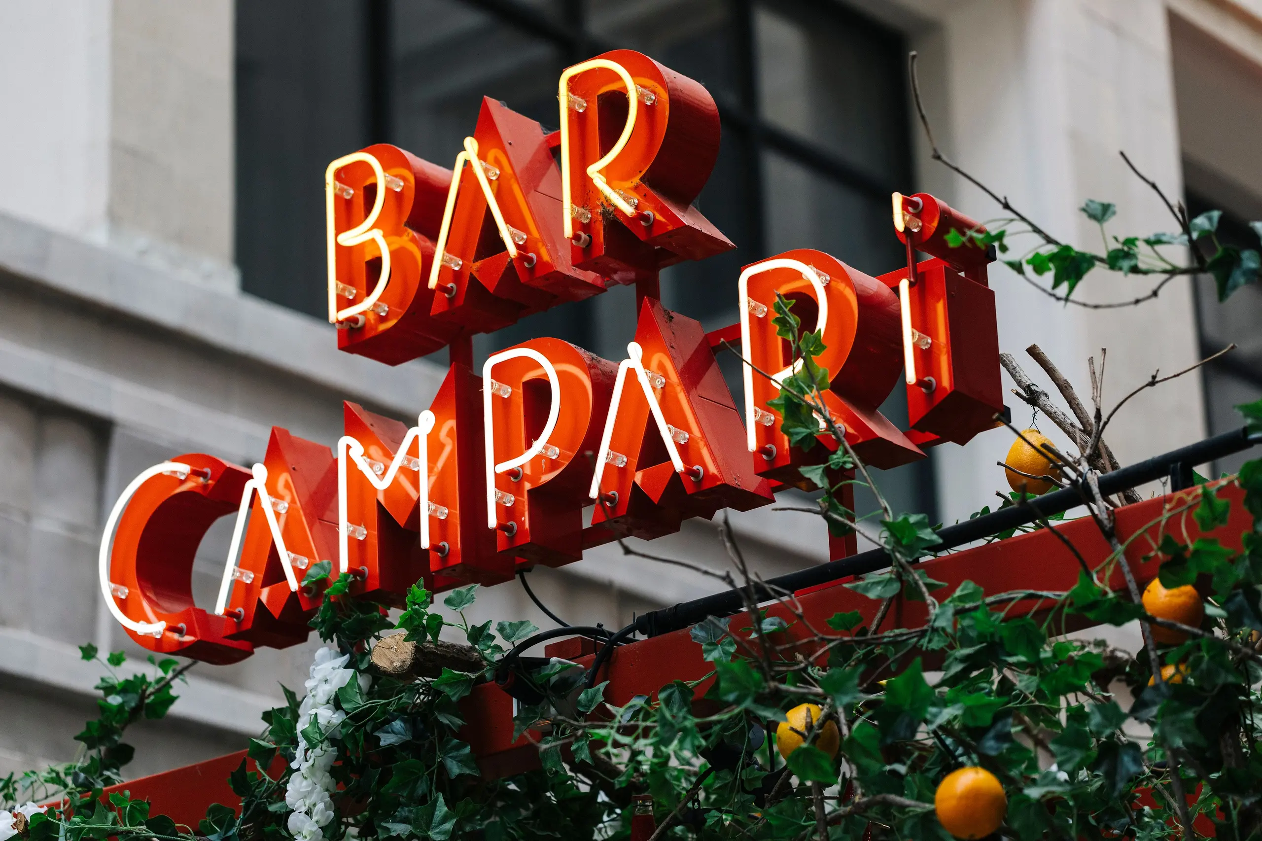 Leuchtschrift „Bar Campari“ an einer Hausfassade